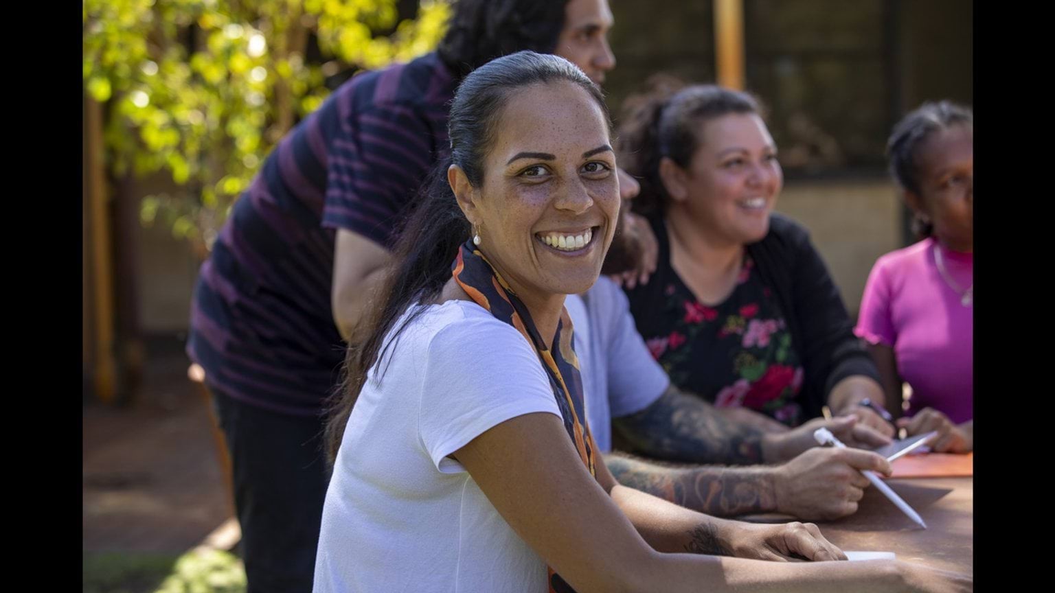 A shared vision for Aboriginal social and emotional wellbeing in Victoria A group of people around a table, one is looking directly at the camera
