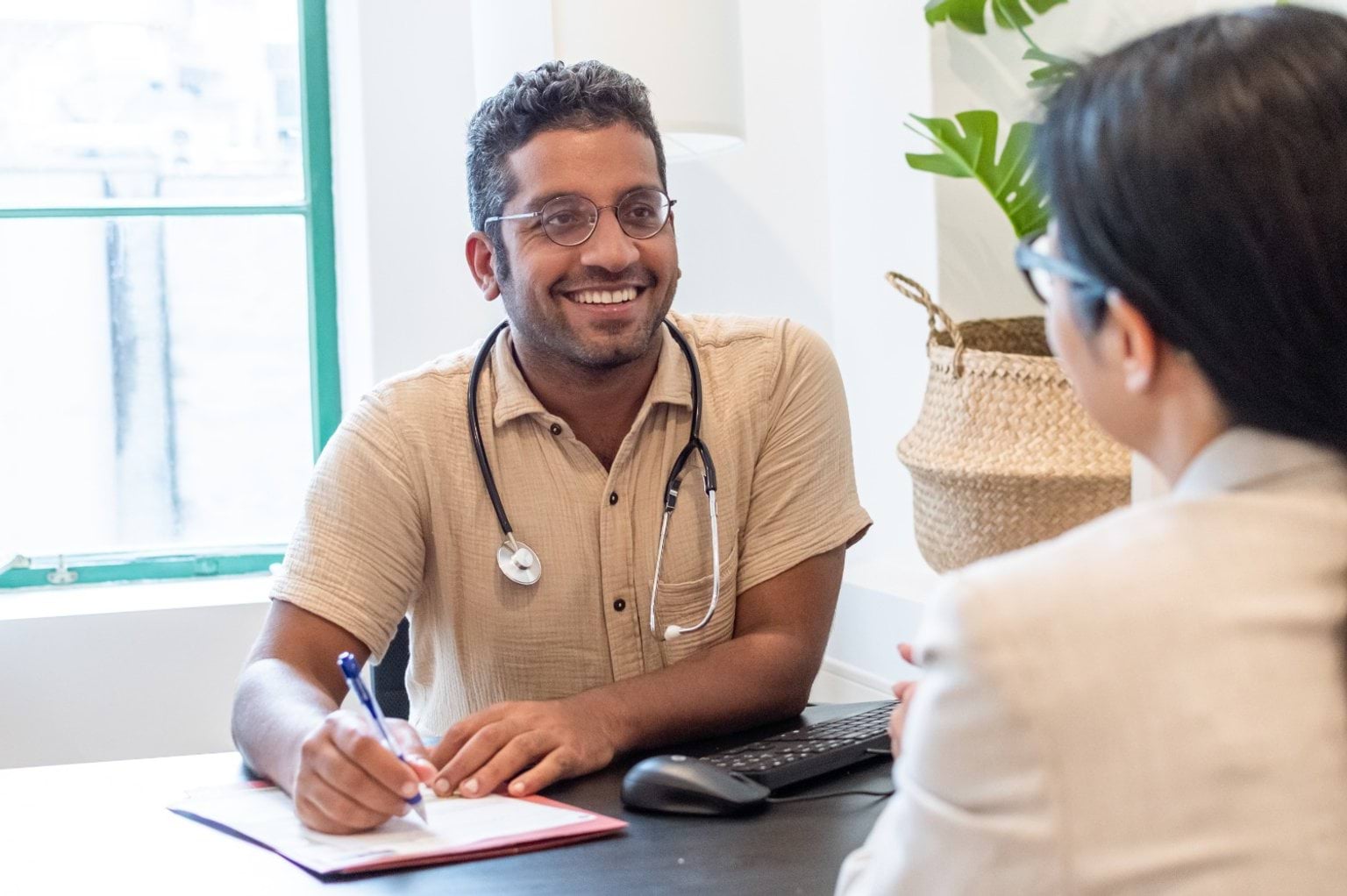 Work as a Specialist International Medical Graduate in Victoria Doctor smiles across a desk to his patient