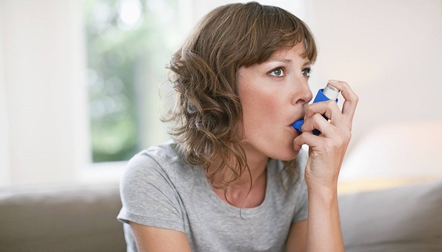 Woman using asthma puffer